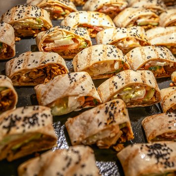 Ein ansprechendes Buffet mit verschiedenen Wraps, die in gleichmäßigen Reihen angeordnet sind, lädt zum Genießen ein.