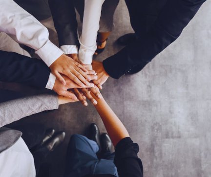 Mehrere Hände übereinander legend