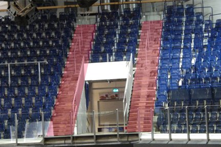 Die Tribüne der Arena Nürnberg zeigt eine auffällige Treppe in Rot und Blau, die zu einem Zugang führt.