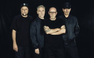 Die vier Jungs von den Fanta 4 stehen vor einem schwarzen Hintergrund