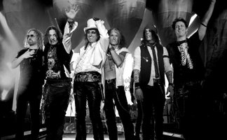 Die 6 Mitglieder der Band auf der Bühne in schwarz-weiß