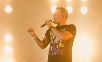 Marc Martel singend auf der Bühne mit heller Bühnenbeleuchtung