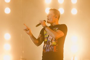 Marc Martel singend auf der Bühne mit heller Bühnenbeleuchtung