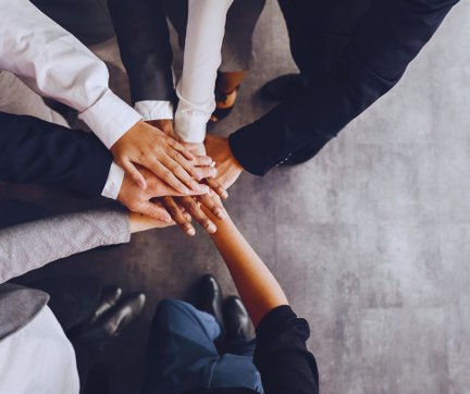 Mehrere Hände übereinander legend