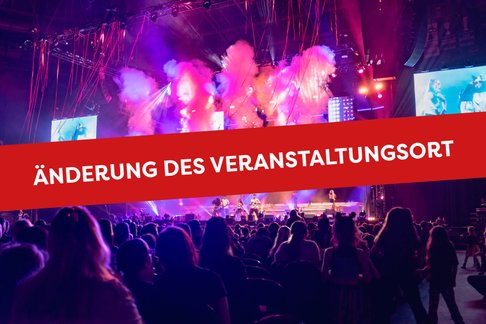 Eine lebhafte Konzertszene mit bunten Lichtern und Nebel, während das Publikum gespannt zuschaut.